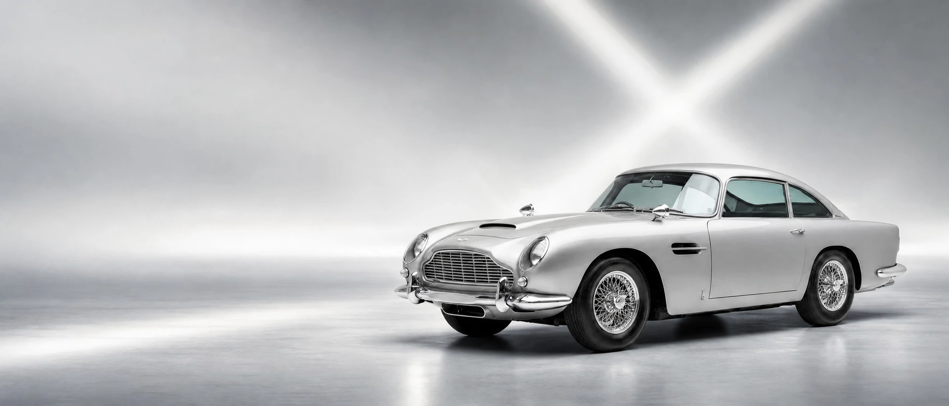 A Silver Birch Aston Martin DB5 Goldfinger Continuation, front three-quarter view on a silver field with crossing light beams