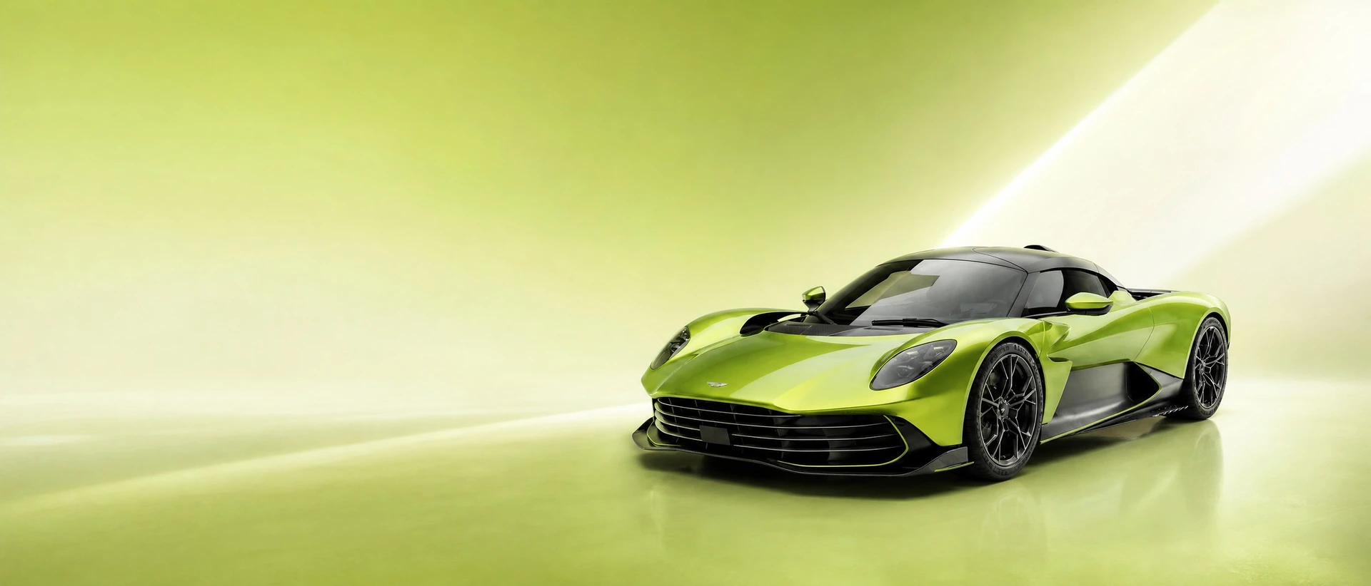 A lime-green Aston Martin Valhalla, front three-quarter view on a lime-to-white field with a blade of light
