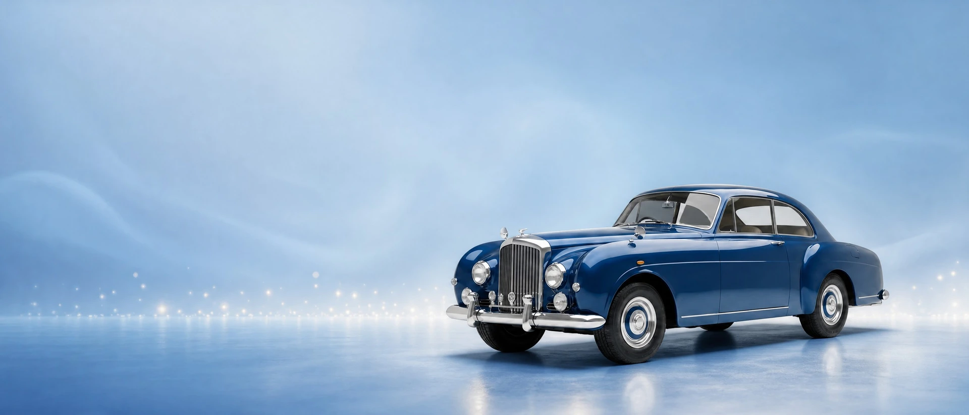 A blue Bentley S-Series Continental, front three-quarter view on a powder-blue field with light sparkle