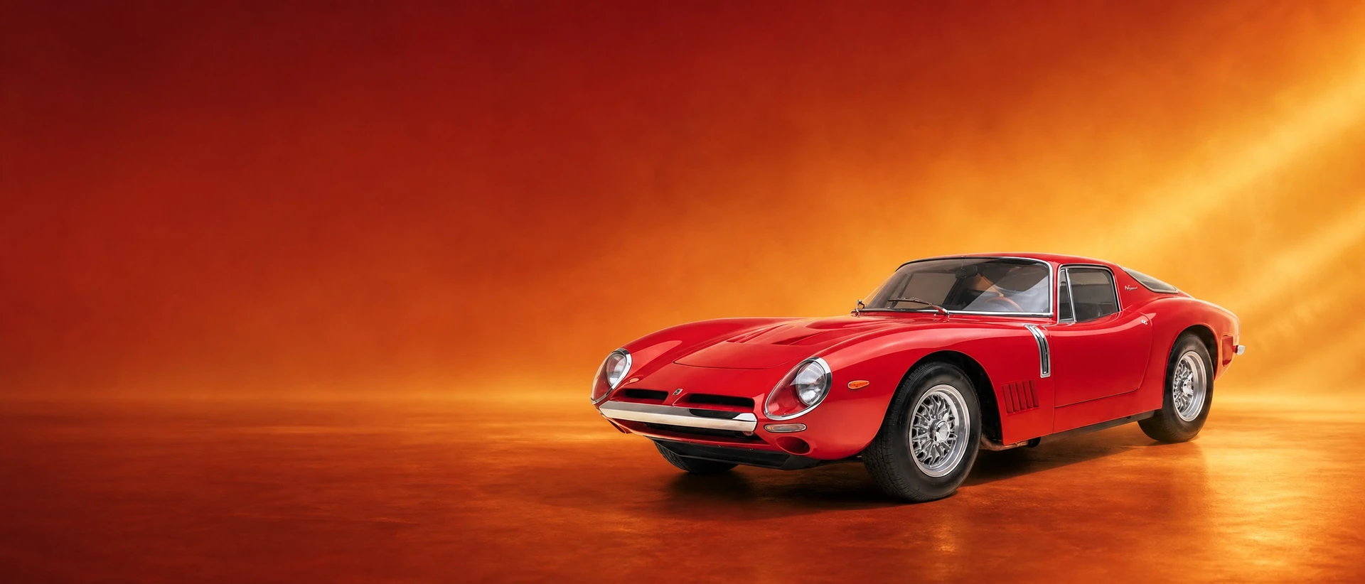 A red Bizzarrini 5300 GT Strada, front three-quarter view on an amber field with raking light