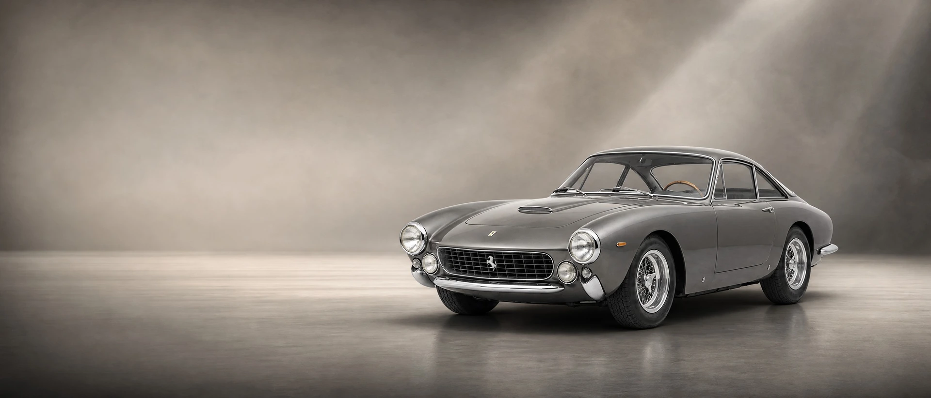 A metallic grey Ferrari 250 GT Lusso, front three-quarter view on a warm grey field with gallery light