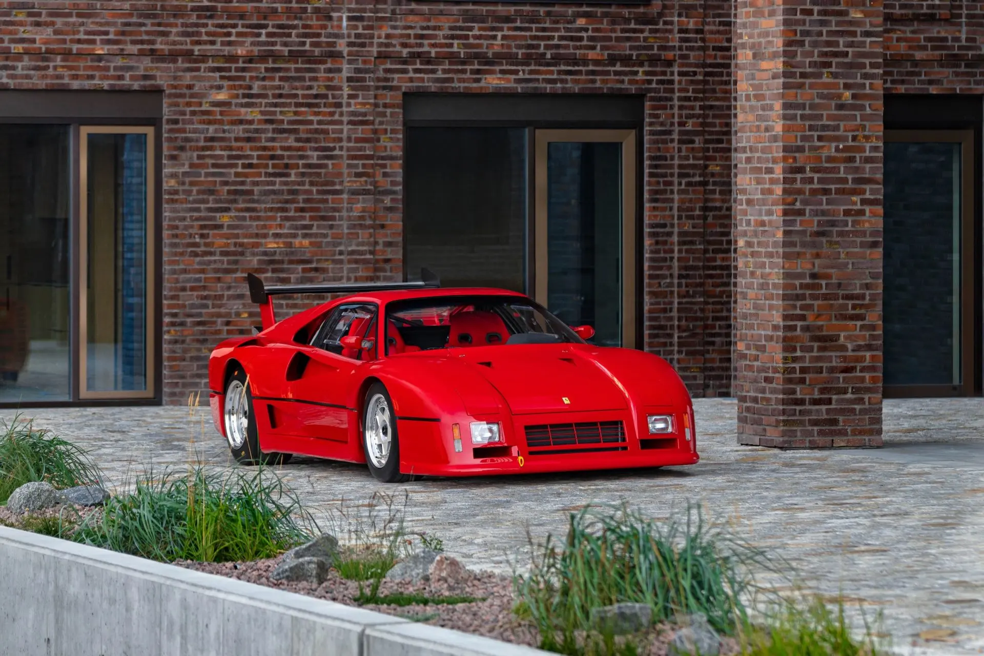 Ferrari GTO Evoluzione in front-three-quarter view outside a brick building