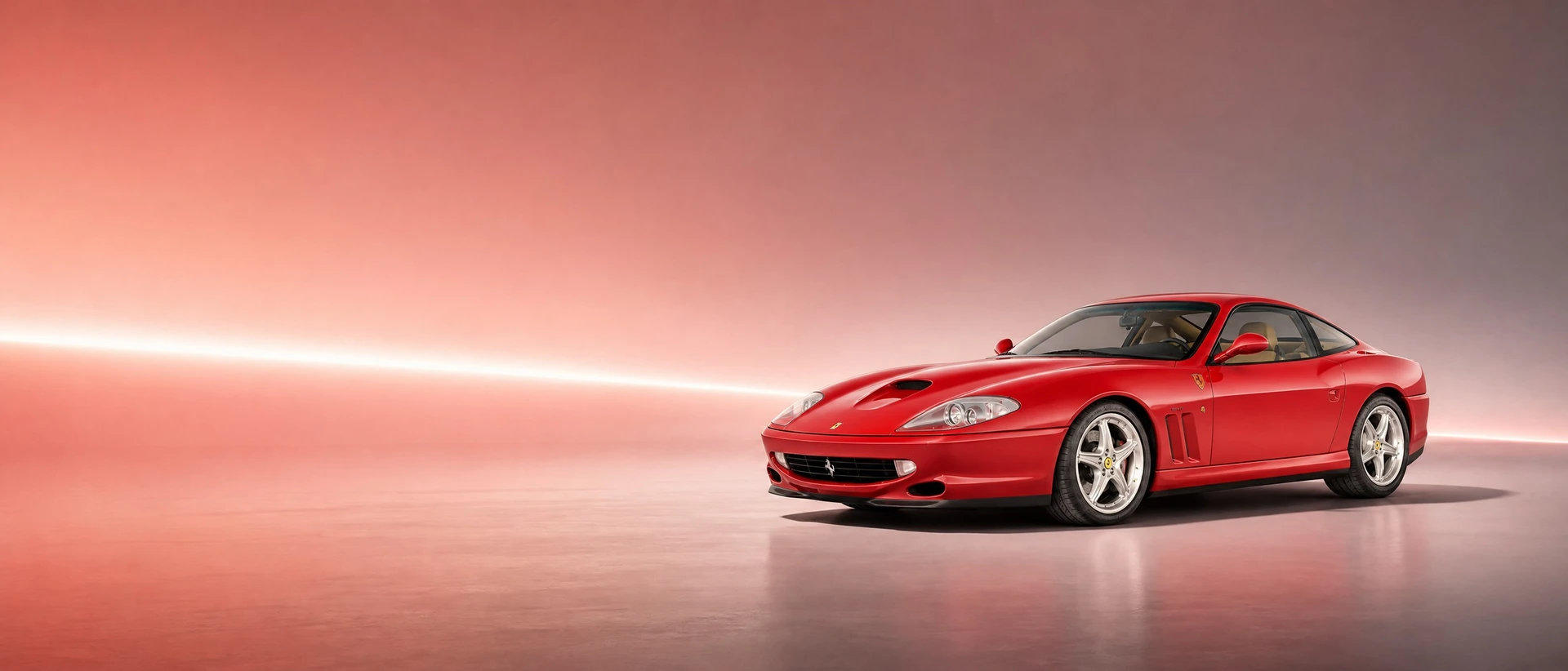 A red Ferrari 550 Maranello, front three-quarter view on a blue-silver field with a vanishing light line