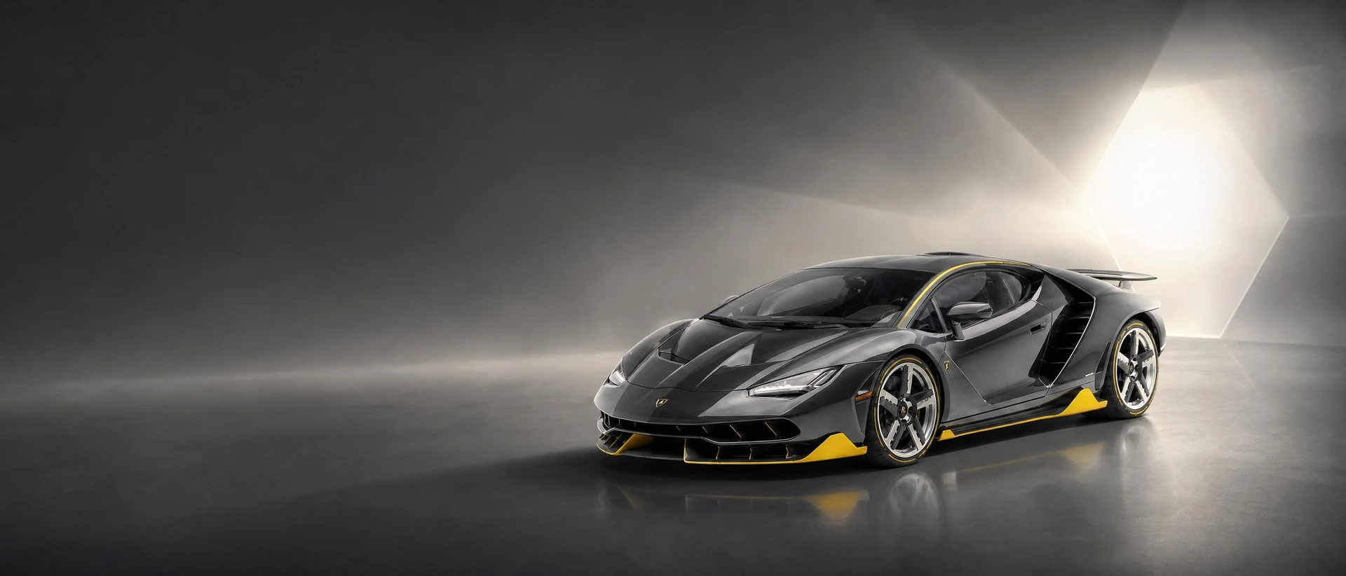 A grey carbon Lamborghini Centenario, front three-quarter view on a carbon-grey field with a hexagonal bloom
