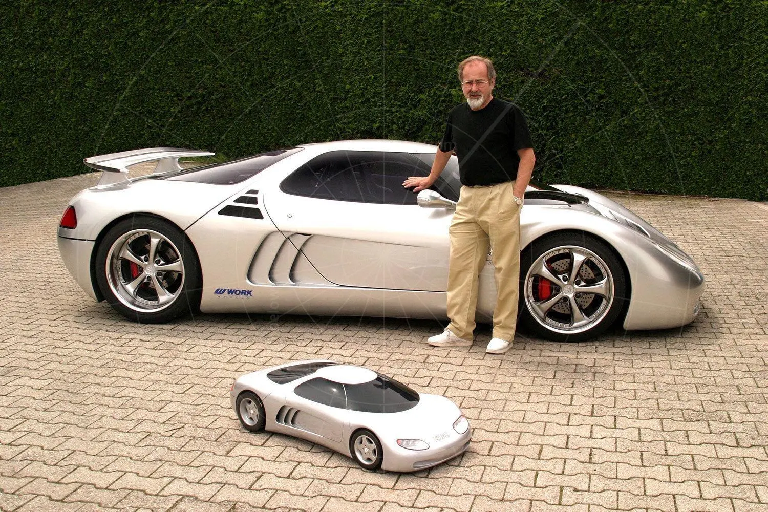 Kurt Lotterschmid standing beside the finished Sirius with the original quarter-scale styling model in front