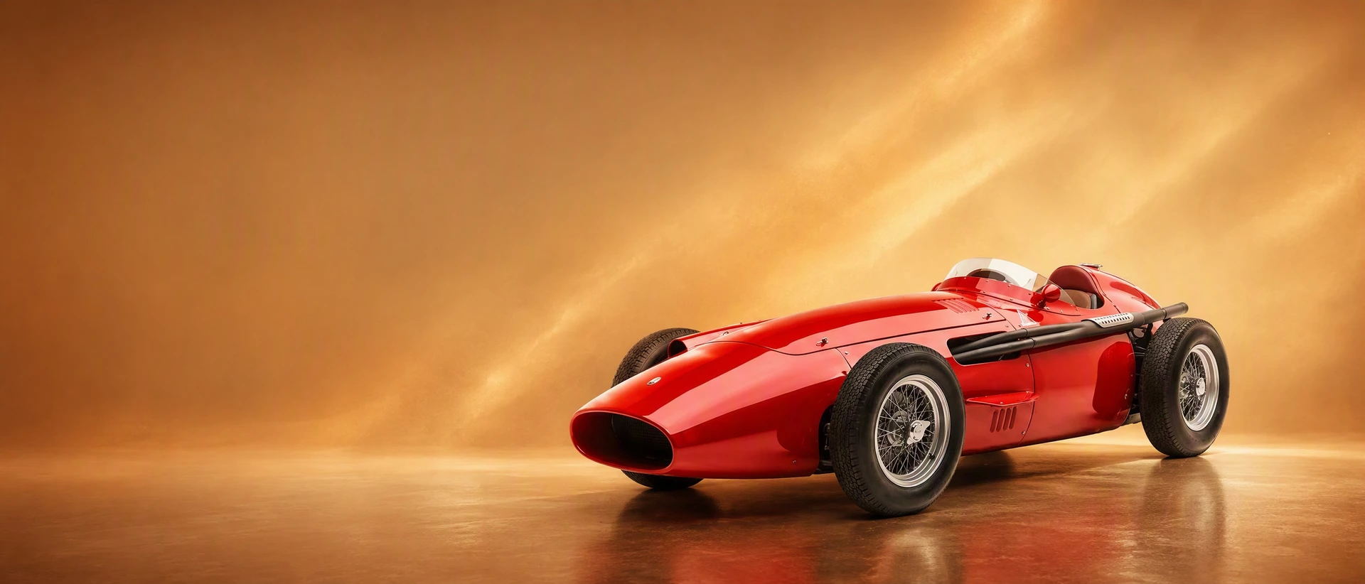 A red Maserati 250F Grand Prix car, front three-quarter view on a sepia-gold field with drifting dust
