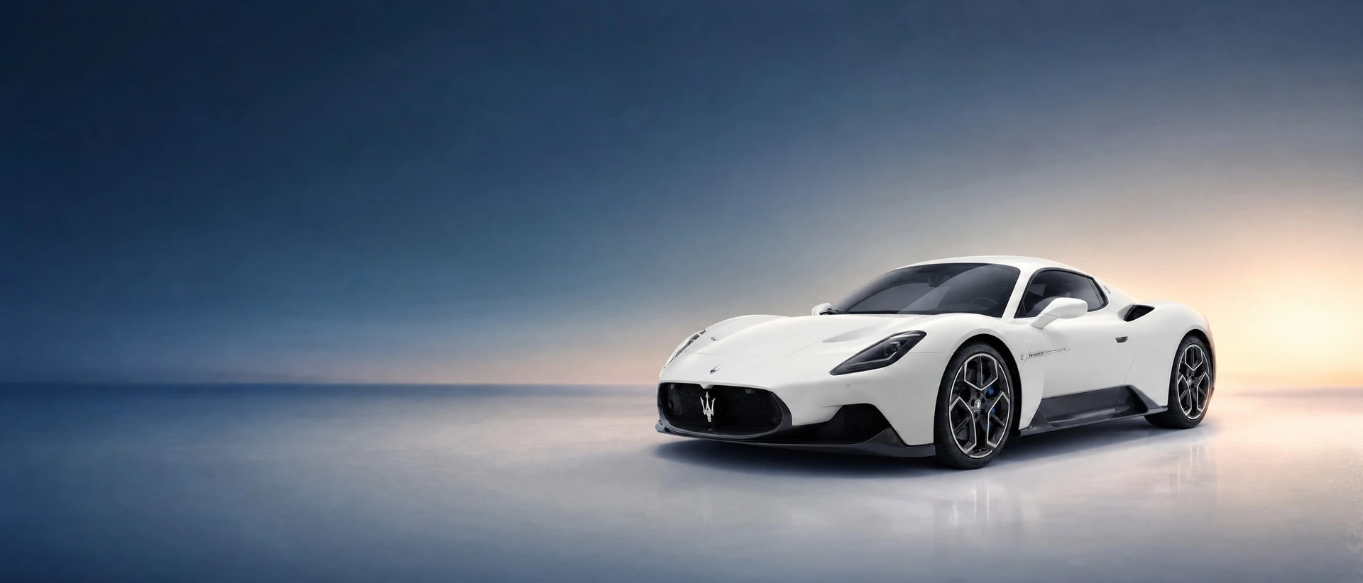 A Maserati MC20, front three-quarter view on a blue field with breaking dawn light