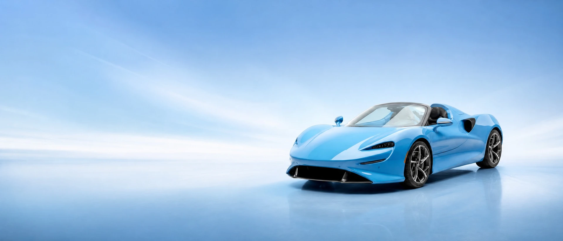 A light blue McLaren Elva, front three-quarter view on a sky-blue field with a bright horizon