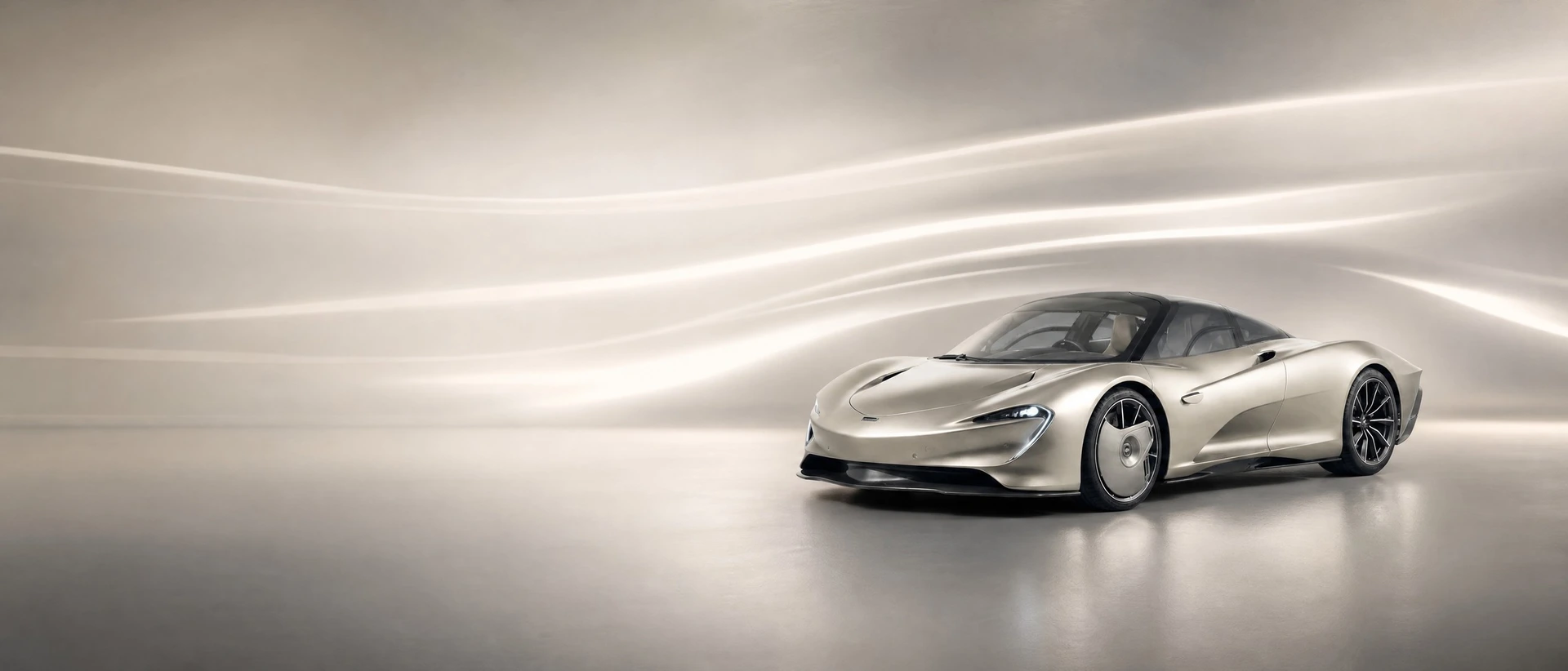 A silver McLaren Speedtail, front three-quarter view on a silver field with teardrop light