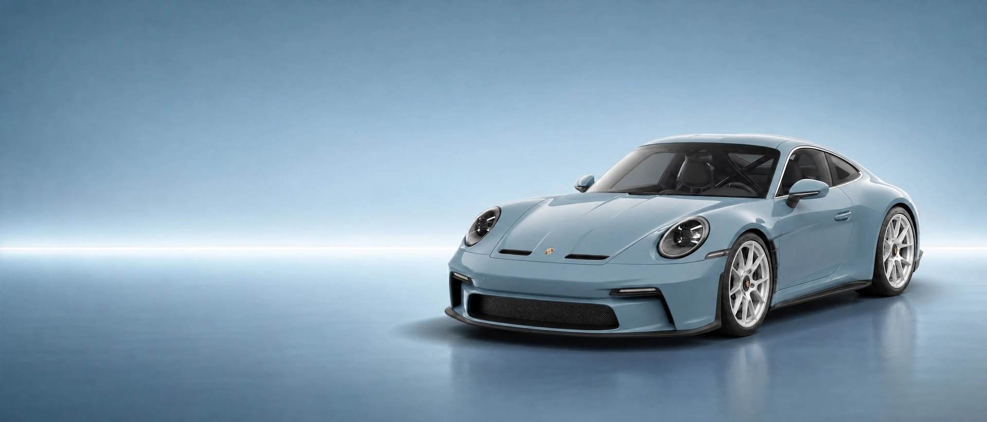 A Shore Blue Metallic Porsche 911 S/T, front three-quarter view on a shore-blue field with a calm horizon