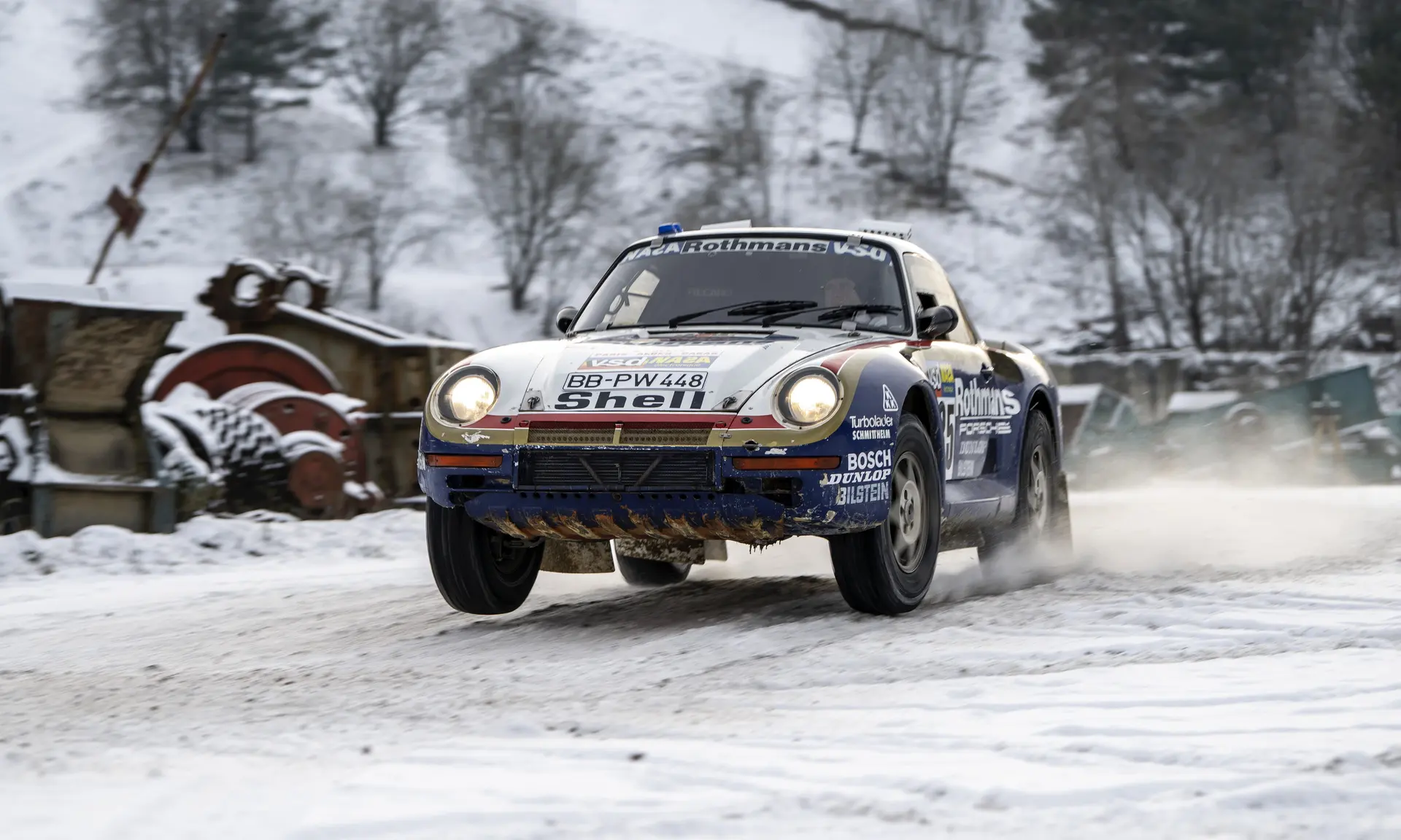 A Rothmans-liveried Porsche 959 on a snowy rally stage