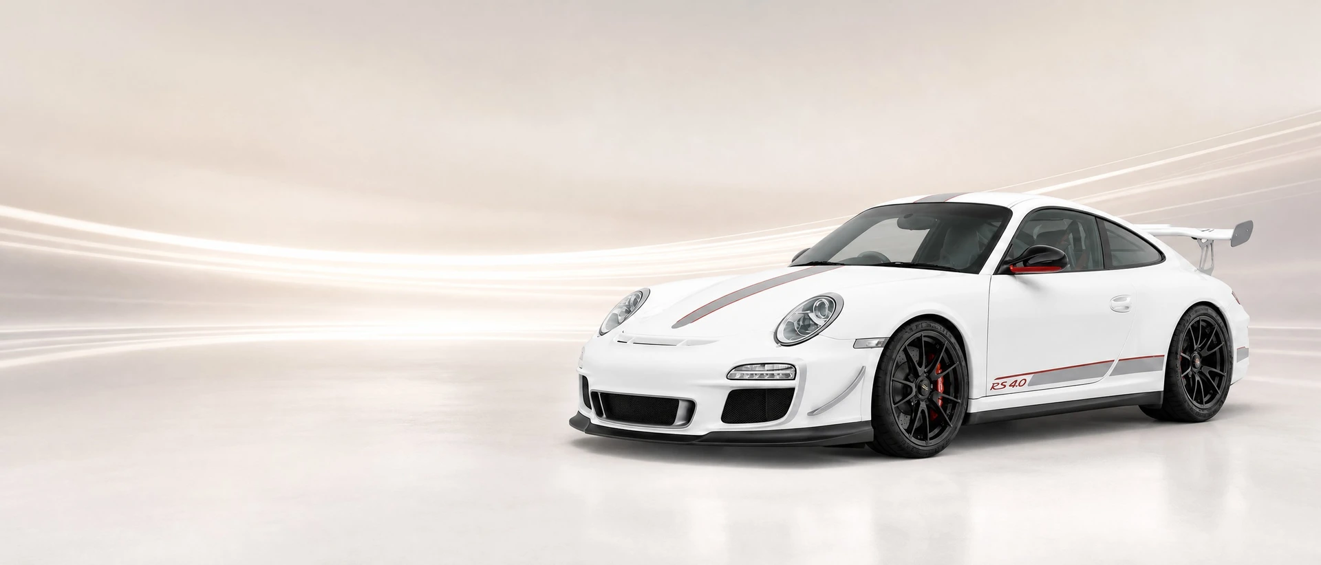 A white Porsche 997 GT3 RS 4.0 with red graphics, front three-quarter view with four merging light bands