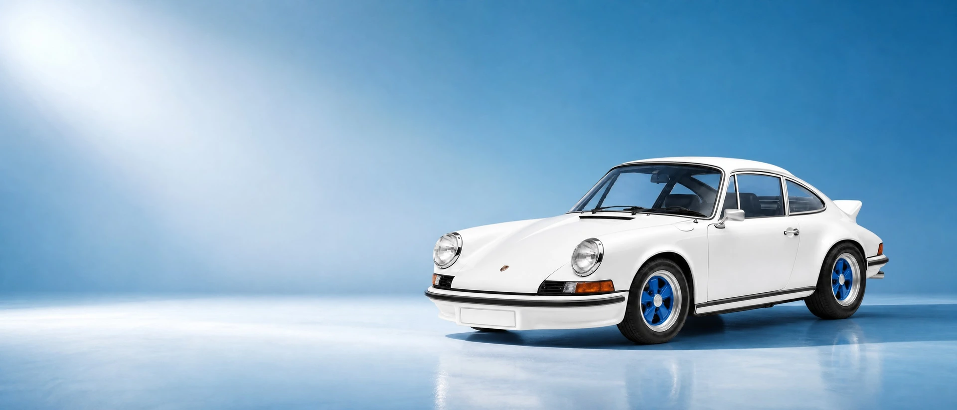 A Porsche 911 Carrera RS 2.7 with ducktail spoiler, front three-quarter view on a fresh blue morning field