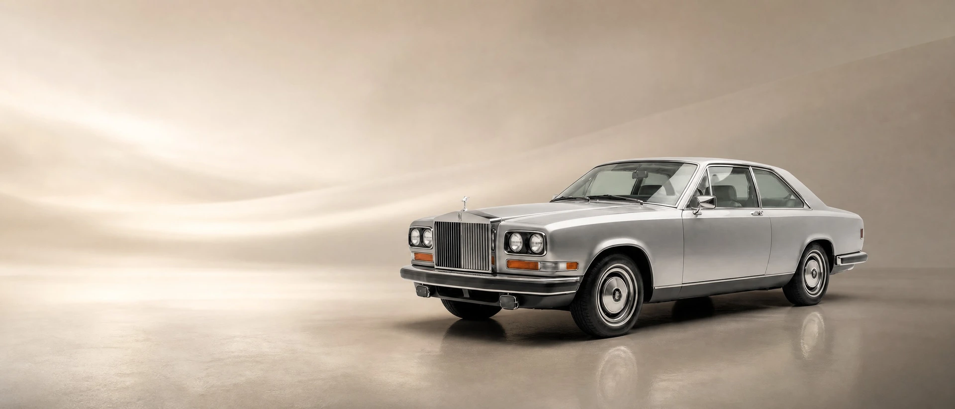 A Rolls-Royce Camargue, front three-quarter view on a warm stone-toned field