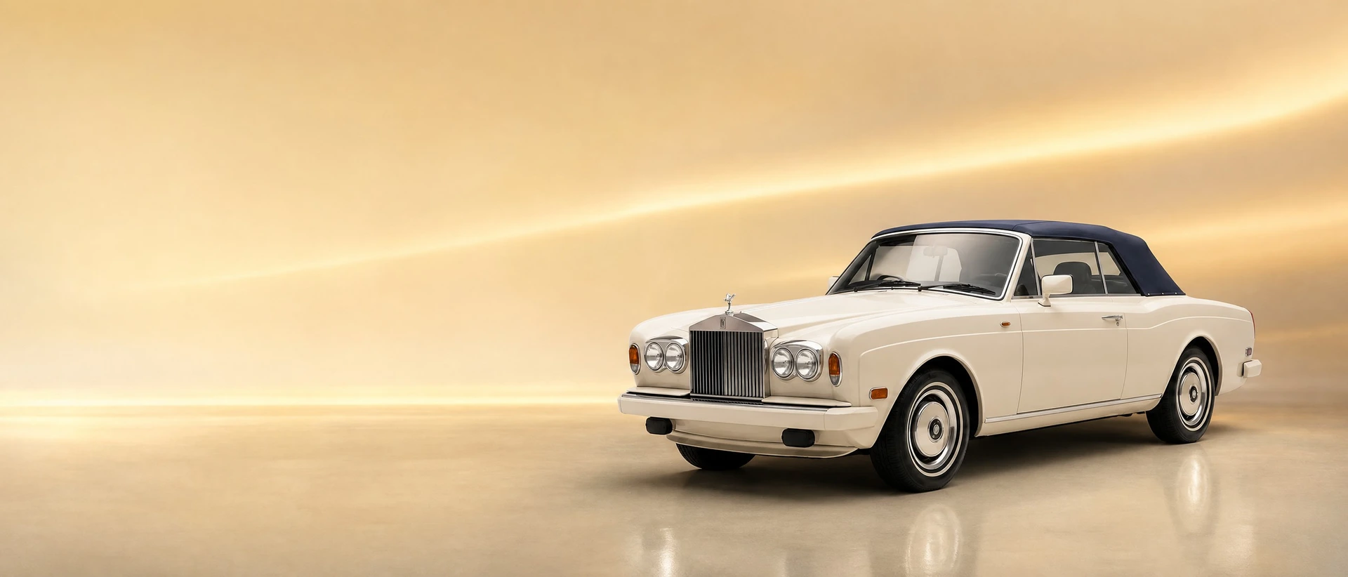 A Rolls-Royce Corniche, front three-quarter view on a golden field with a soft light string