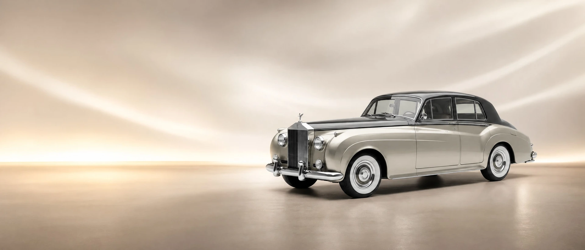 A Rolls-Royce Silver Cloud, front three-quarter view on a pearl cloud-light field