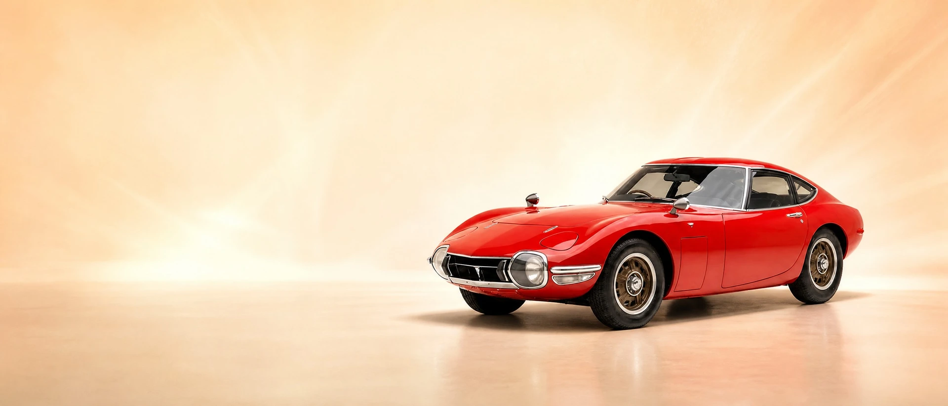 A Solar Red Toyota 2000GT, front three-quarter view on an ivory field with a rising-sun glow