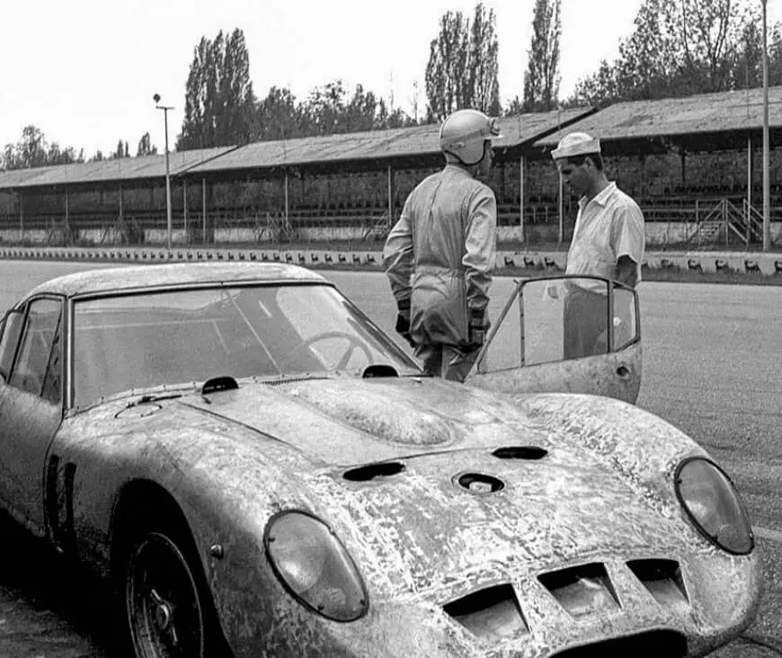Giotto Bizzarrini in a white shirt beside the Ferrari 250 GTO prototype at Monza, 1961