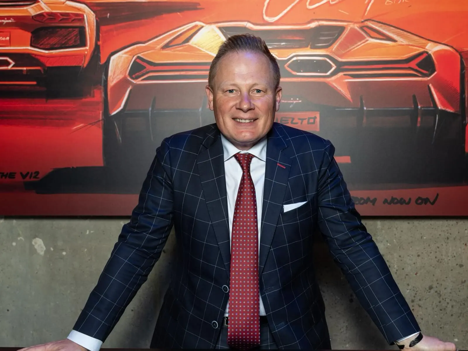 Mitja Borkert, Lamborghini Head of Design, photographed in front of vehicle-design sketches.